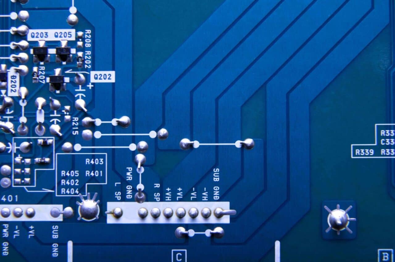 A close-up of a blue electronic circuit board, showcasing intricate patterns and components
