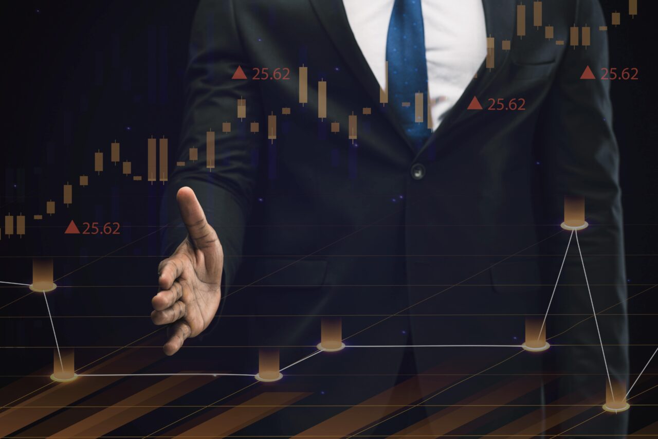A man in a suit gesturing towards a chart.